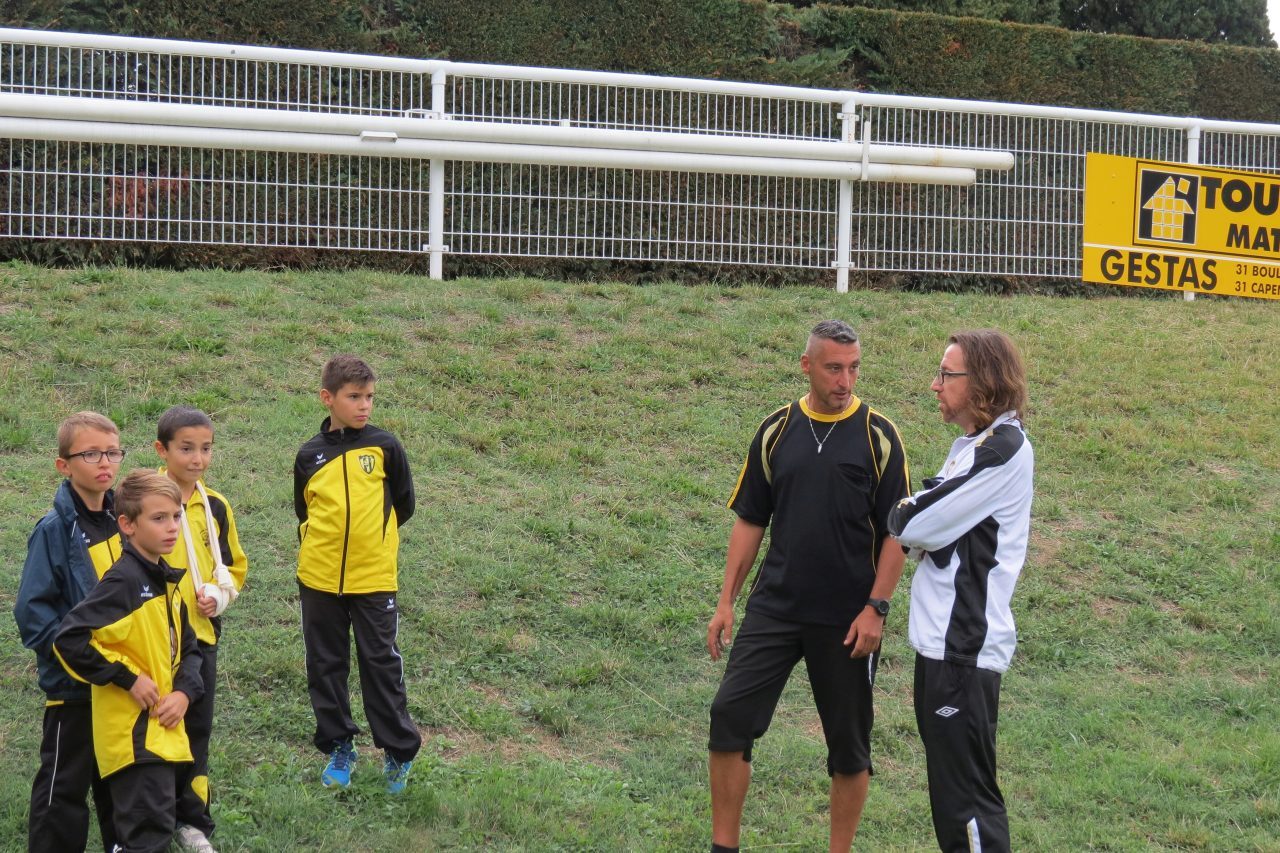 F.Andres, en blanc, donne quelques conseils à un joueur Sénior écouté attentivement par des jeunes du club.